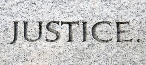7400272-The-word-justice-carved-in-stone-Stock-Photo